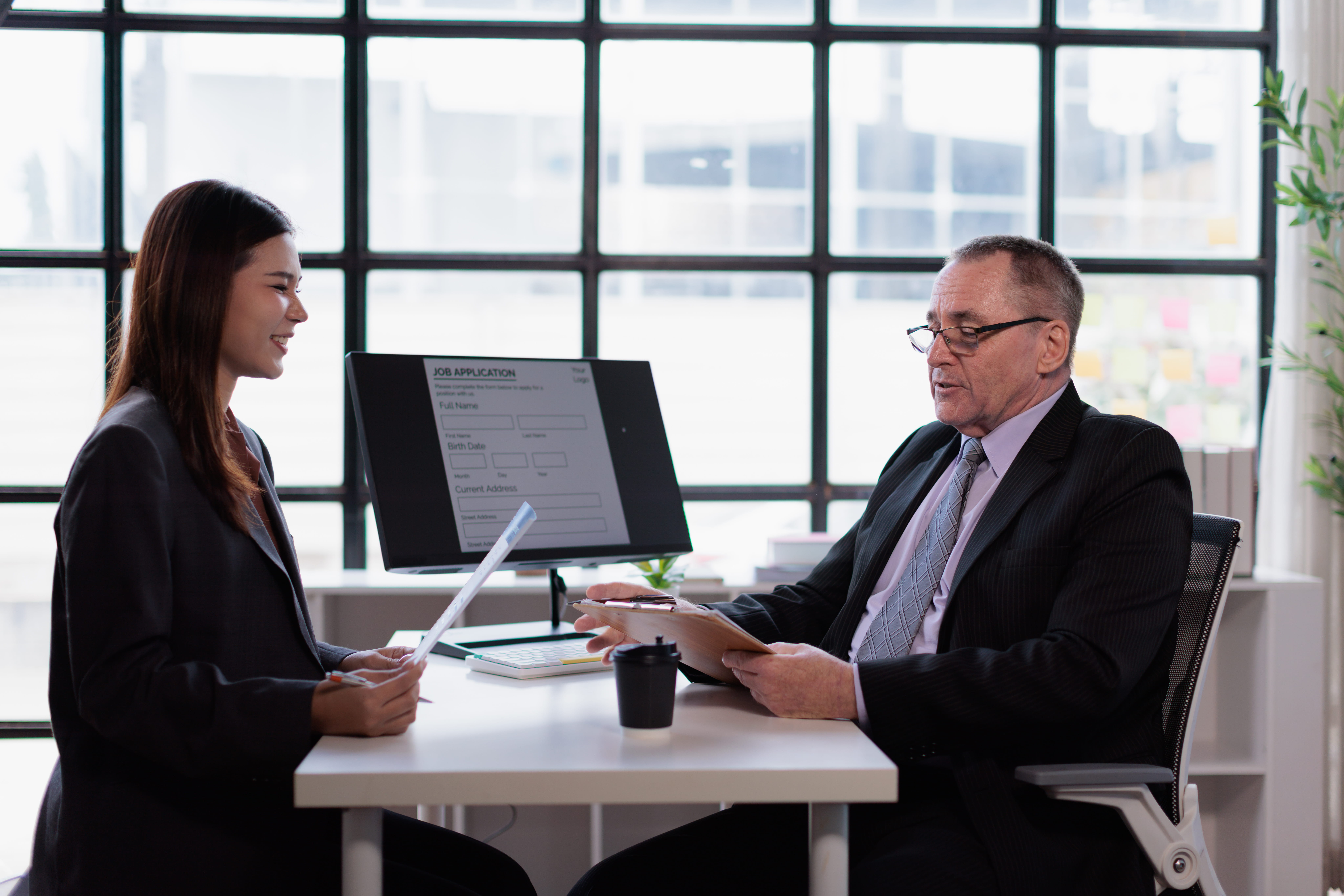 Formation entretien de recrutement : une recruteuse RH échange avec un candidat autour de son CV lors d'un entretien structuré