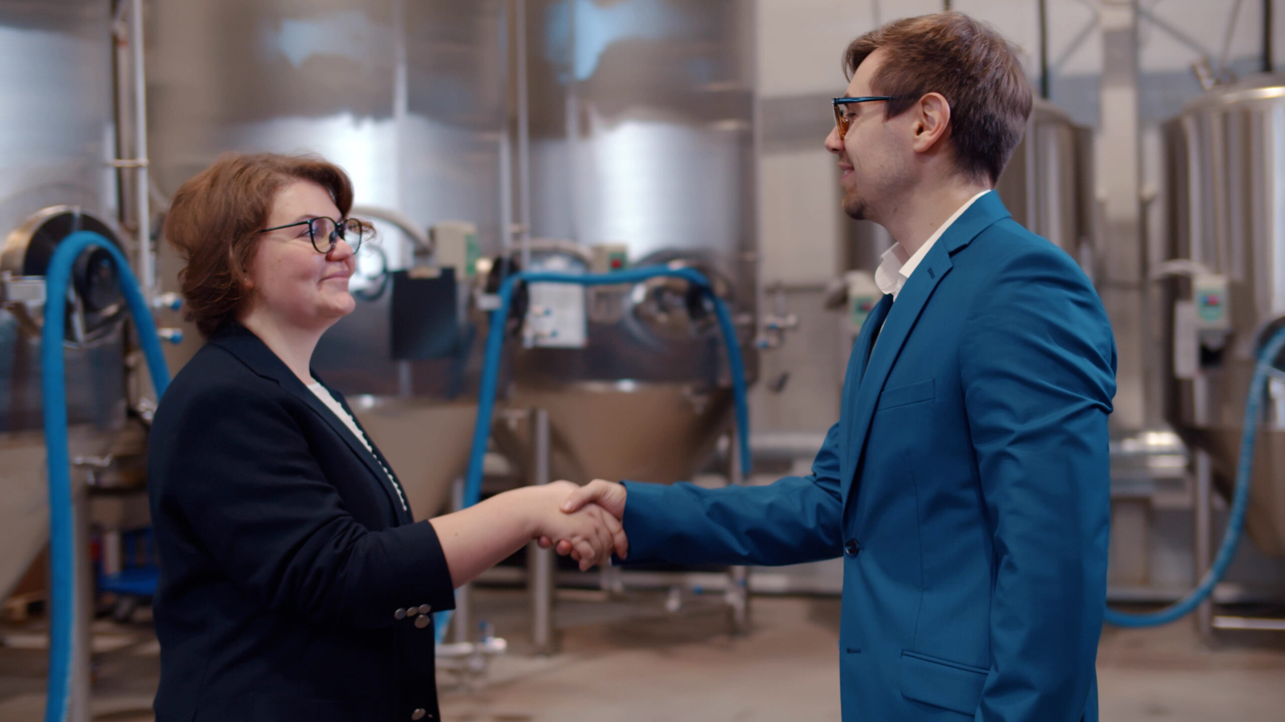 Poignée de main entre deux professionnels dans une usine agroalimentaire illustrant un outplacement cadre